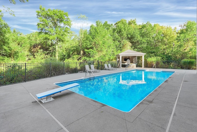 view of pool featuring a gazebo, a diving board, and a patio area