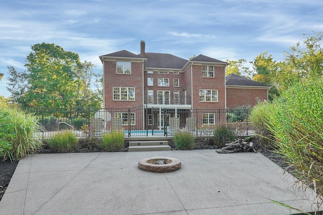 rear view of house featuring an outdoor fire pit and a patio area