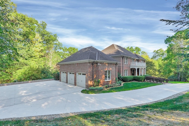 view of front of property with a garage, a balcony, and a front yard