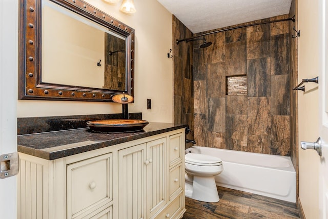 7873 Tullymore Dr, Dublin, OH 43016 - full bathroom featuring hardwood / wood-style flooring, tiled shower / bath combo, vanity, a textured ceiling, and toilet