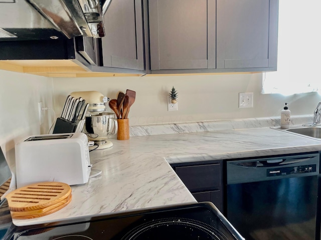 kitchen with light stone counters, sink, gray cabinets, and dishwasher