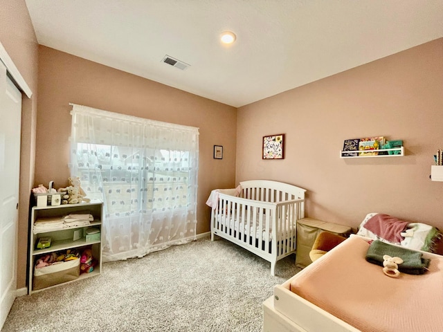 bedroom featuring a closet, carpet floors, and a nursery area