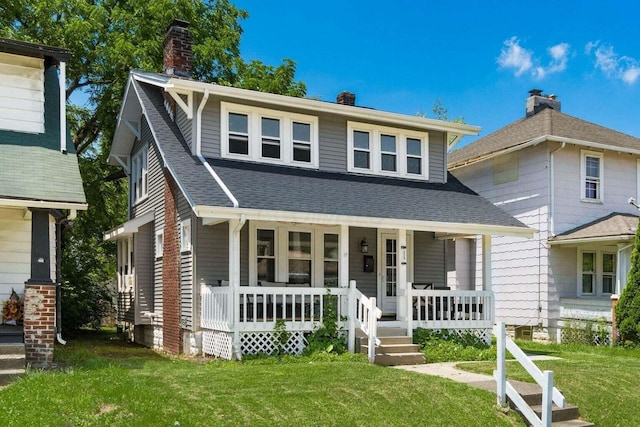 view of front of house with covered porch and a front lawn