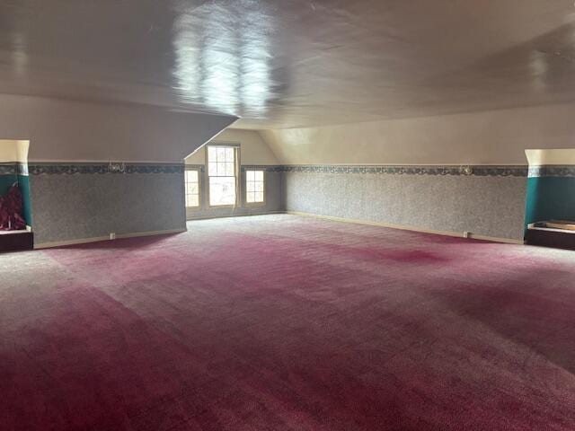 additional living space featuring lofted ceiling and carpet floors