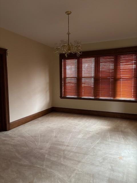 unfurnished dining area featuring lofted ceiling, carpet flooring, and an inviting chandelier