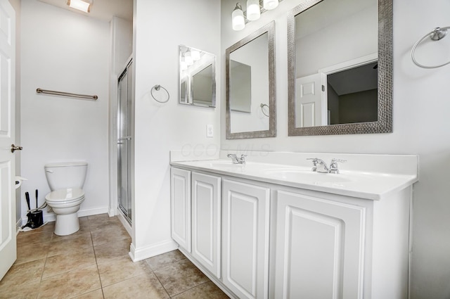 bathroom with a shower with door, vanity, tile patterned floors, and toilet