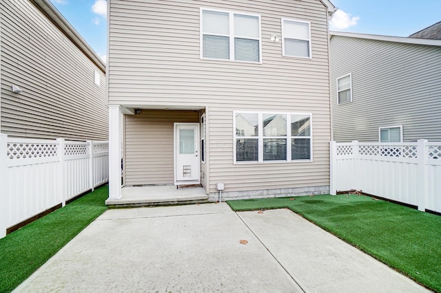 rear view of property with a yard and a patio