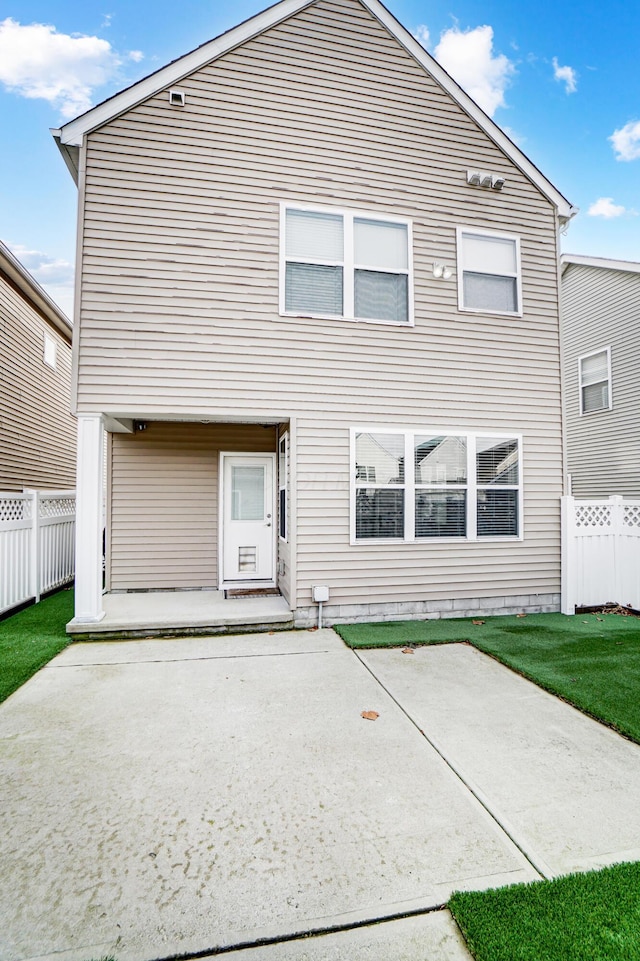 back of property with a yard and a patio area