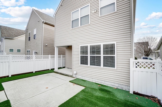 back of house with a lawn and a patio area