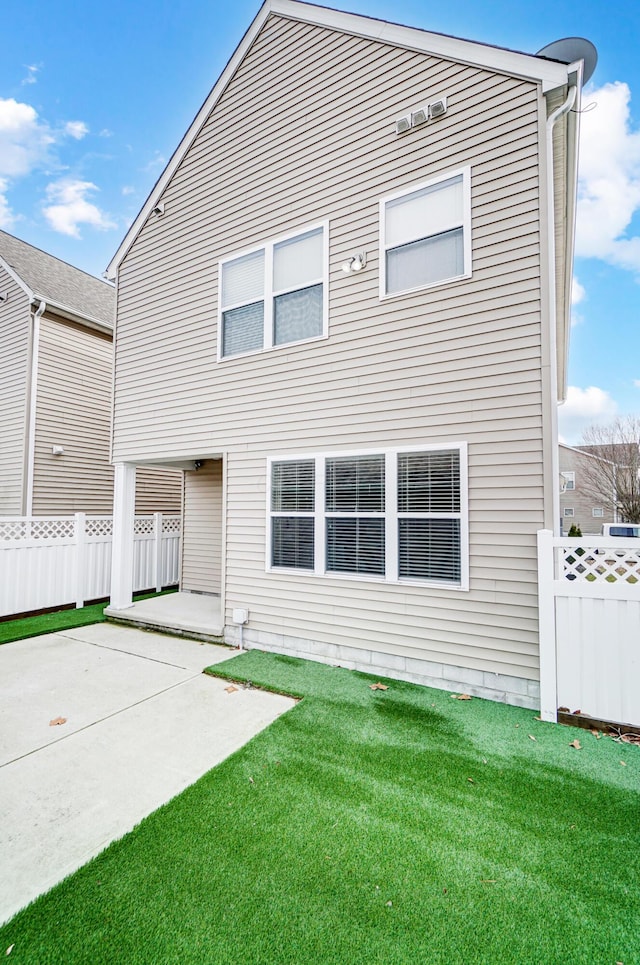 back of house with a lawn and a patio area