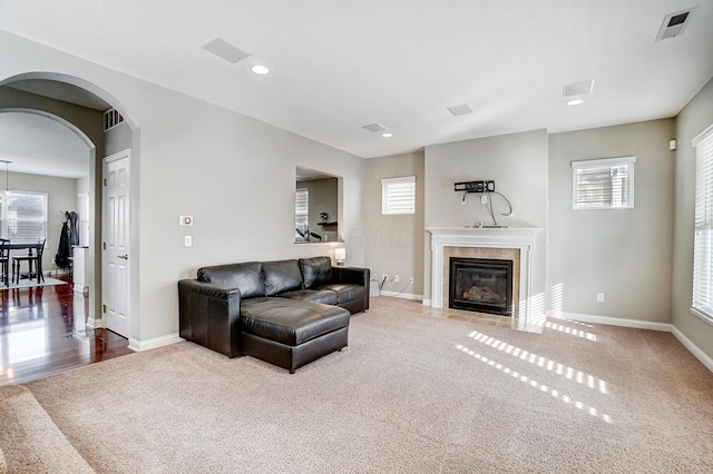 carpeted living room with plenty of natural light and a tiled fireplace