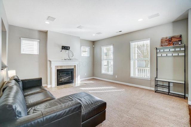 carpeted living room with a tile fireplace