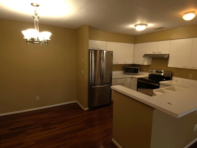 kitchen with white cabinetry, stainless steel appliances, kitchen peninsula, and hanging light fixtures