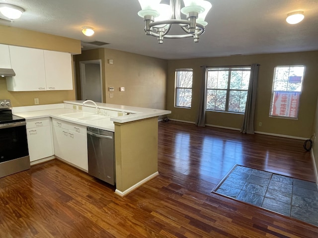 kitchen featuring white cabinetry, appliances with stainless steel finishes, decorative light fixtures, and kitchen peninsula