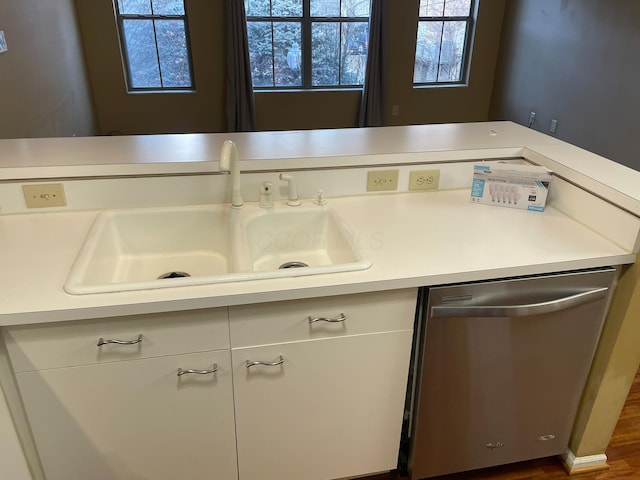 kitchen featuring stainless steel dishwasher, sink, and white cabinets