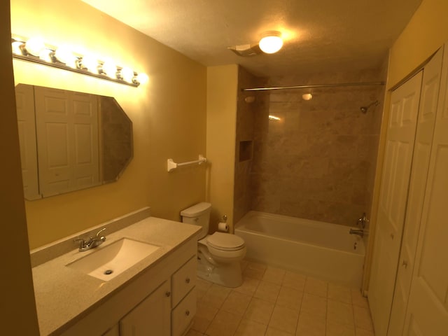 full bathroom featuring tiled shower / bath, vanity, toilet, and tile patterned flooring