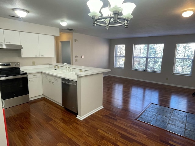 kitchen with under cabinet range hood, dark wood-style floors, open floor plan, appliances with stainless steel finishes, and a peninsula