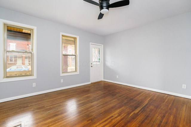 spare room with dark hardwood / wood-style flooring and ceiling fan