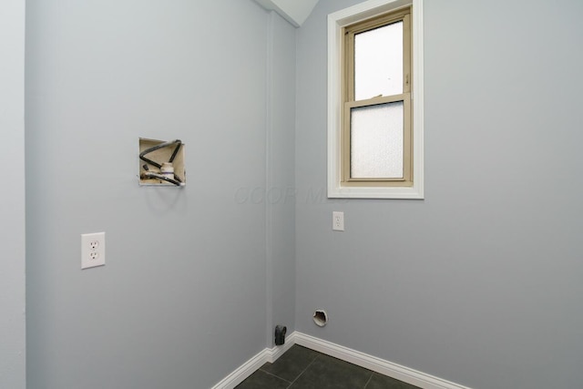 laundry area with hookup for an electric dryer and dark tile patterned floors