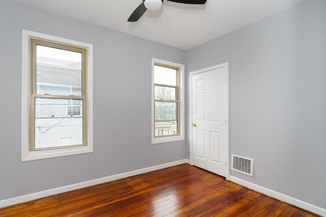 spare room with ceiling fan and dark hardwood / wood-style flooring