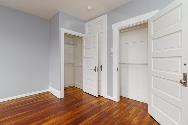 unfurnished bedroom with dark hardwood / wood-style floors and a closet