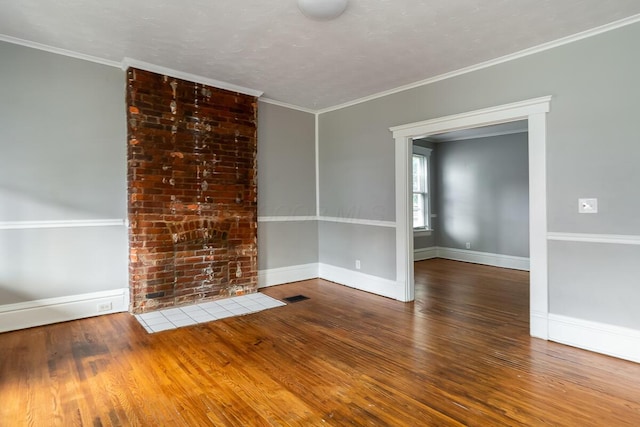 empty room with hardwood / wood-style flooring and crown molding