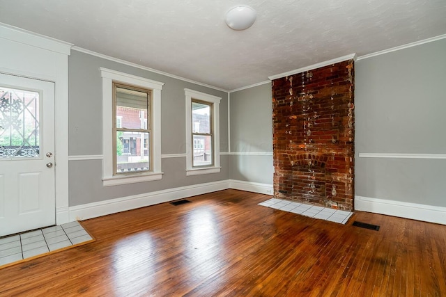 entryway with crown molding and wood-type flooring