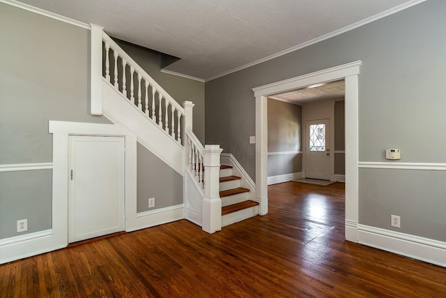 stairway featuring crown molding, hardwood / wood-style flooring, and a textured ceiling