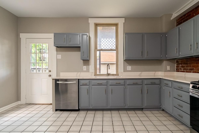 kitchen with gray cabinetry, sink, light tile patterned floors, and stainless steel dishwasher