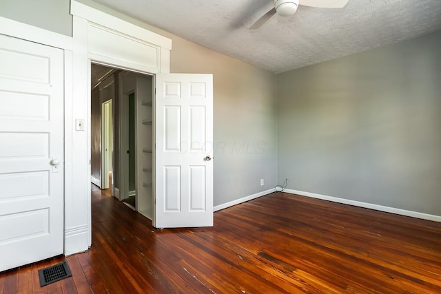 spare room with dark hardwood / wood-style flooring, vaulted ceiling, a textured ceiling, and ceiling fan