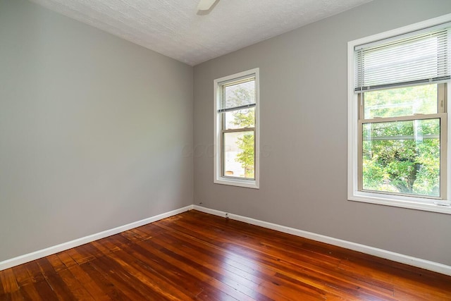 unfurnished room featuring ceiling fan, dark hardwood / wood-style floors, and a textured ceiling