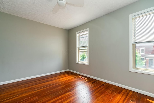 spare room with wood-type flooring, ceiling fan, and a textured ceiling