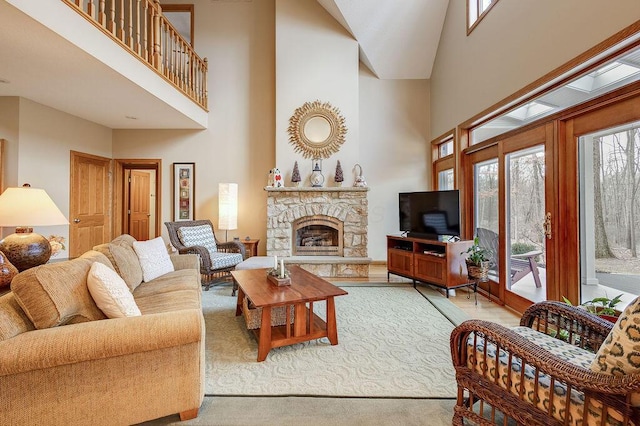 living room with a stone fireplace and a towering ceiling