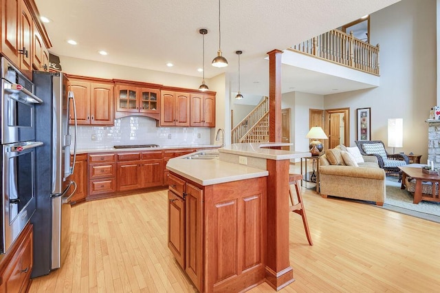 kitchen featuring a kitchen island, a breakfast bar, sink, gas cooktop, and light wood-type flooring