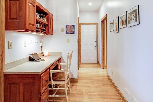 interior space with light hardwood / wood-style flooring and built in desk