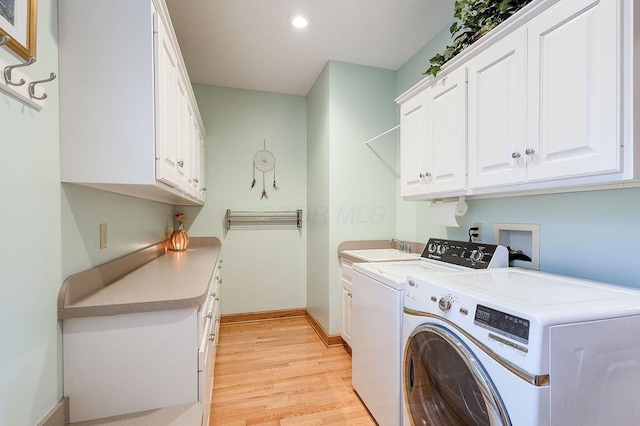 laundry room with cabinets, sink, washer and dryer, and light wood-type flooring