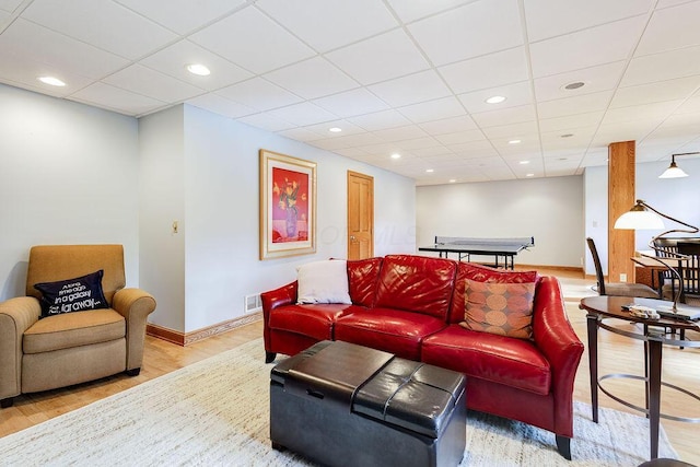 living room featuring a drop ceiling and hardwood / wood-style flooring