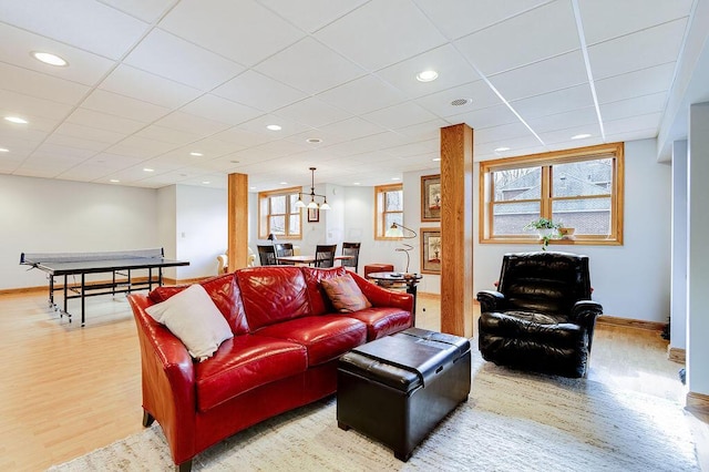 living room featuring plenty of natural light, a paneled ceiling, and light hardwood / wood-style floors