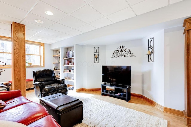 living room with hardwood / wood-style floors and a drop ceiling