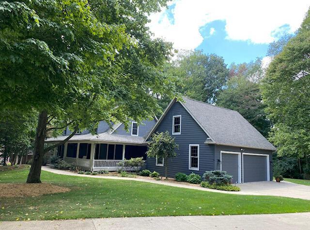 view of front of property with a porch, a garage, and a front yard