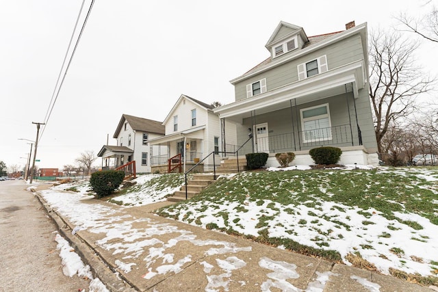 view of front of home with covered porch and a lawn