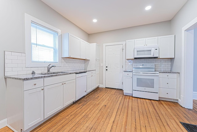 kitchen featuring sink, white appliances, light hardwood / wood-style flooring, and white cabinets