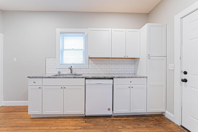 kitchen with light stone counters, sink, white cabinets, and dishwasher