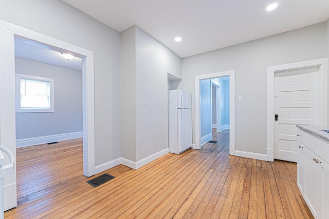 corridor with light hardwood / wood-style flooring