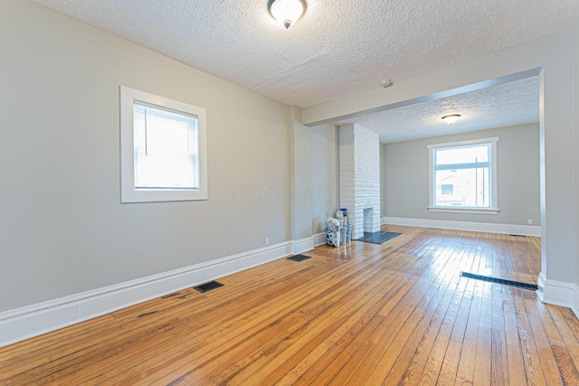 spare room featuring wood-type flooring and a textured ceiling