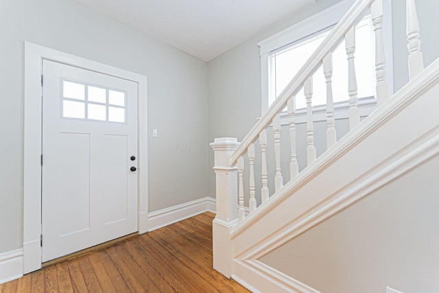 foyer entrance featuring wood-type flooring and a textured ceiling