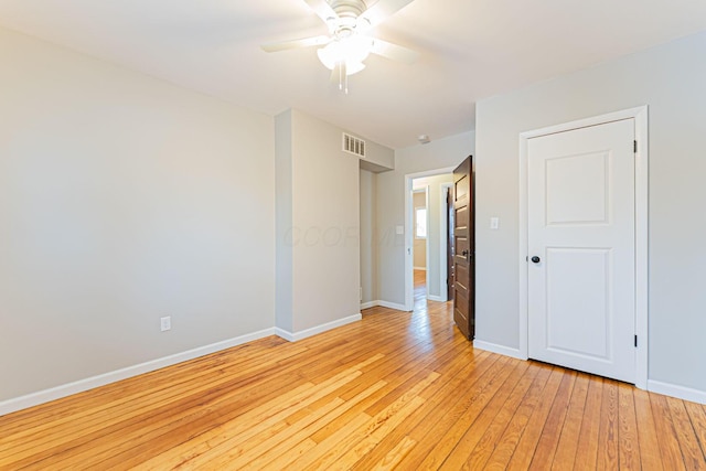 spare room with ceiling fan and light wood-type flooring