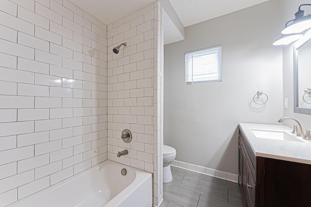 full bathroom featuring tile patterned flooring, tiled shower / bath, vanity, and toilet