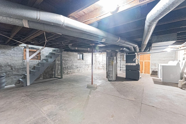 basement featuring gas water heater, separate washer and dryer, and heating unit