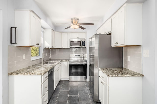 kitchen with white cabinetry, a ceiling fan, appliances with stainless steel finishes, and a sink